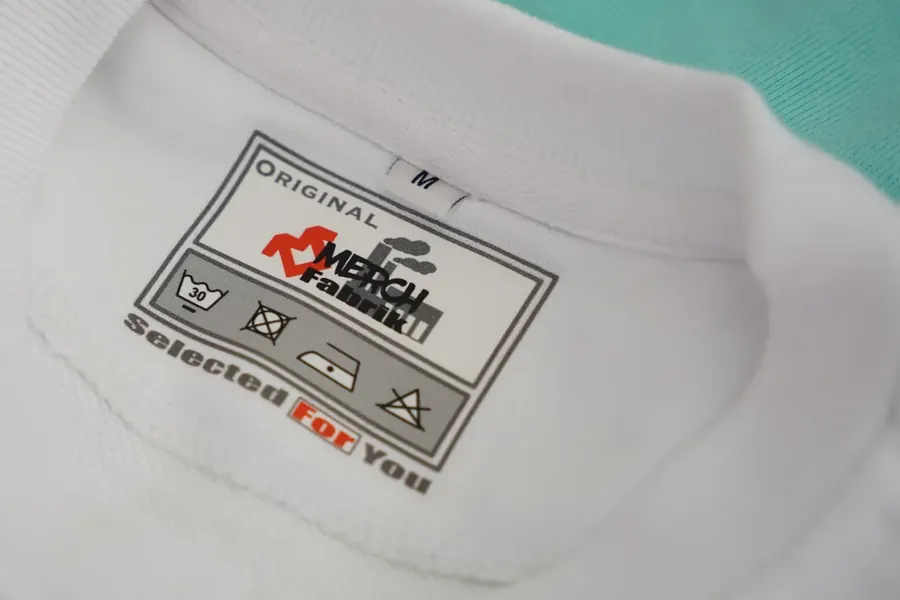 Gewebtes Etikett der Merchfabrik im Kragen eines weissen Shirts
