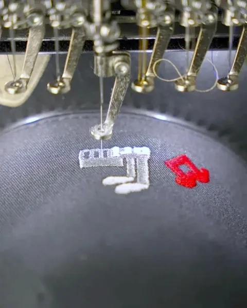 Stickkopf setzt Garn auf eine dunkle Cap