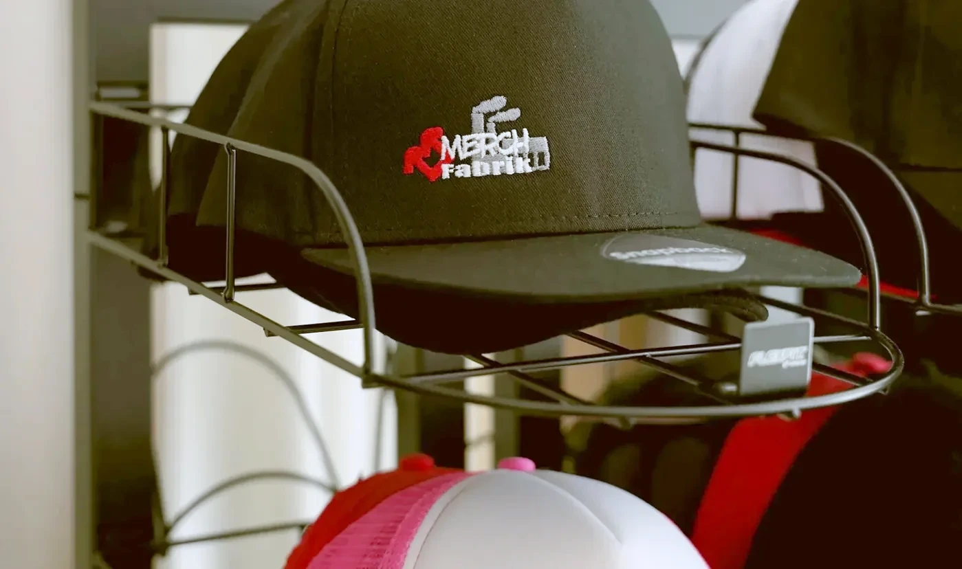 Bestickte Caps im Musterregal der Merchfabrik